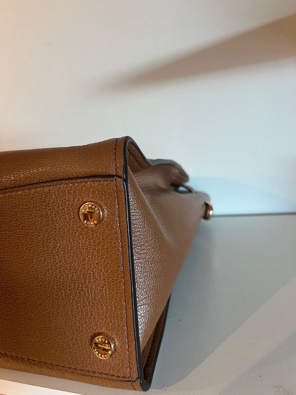 Bolsa tote de couro marrom com duas alças, cinto frontal e cadeado dourado — foto 4