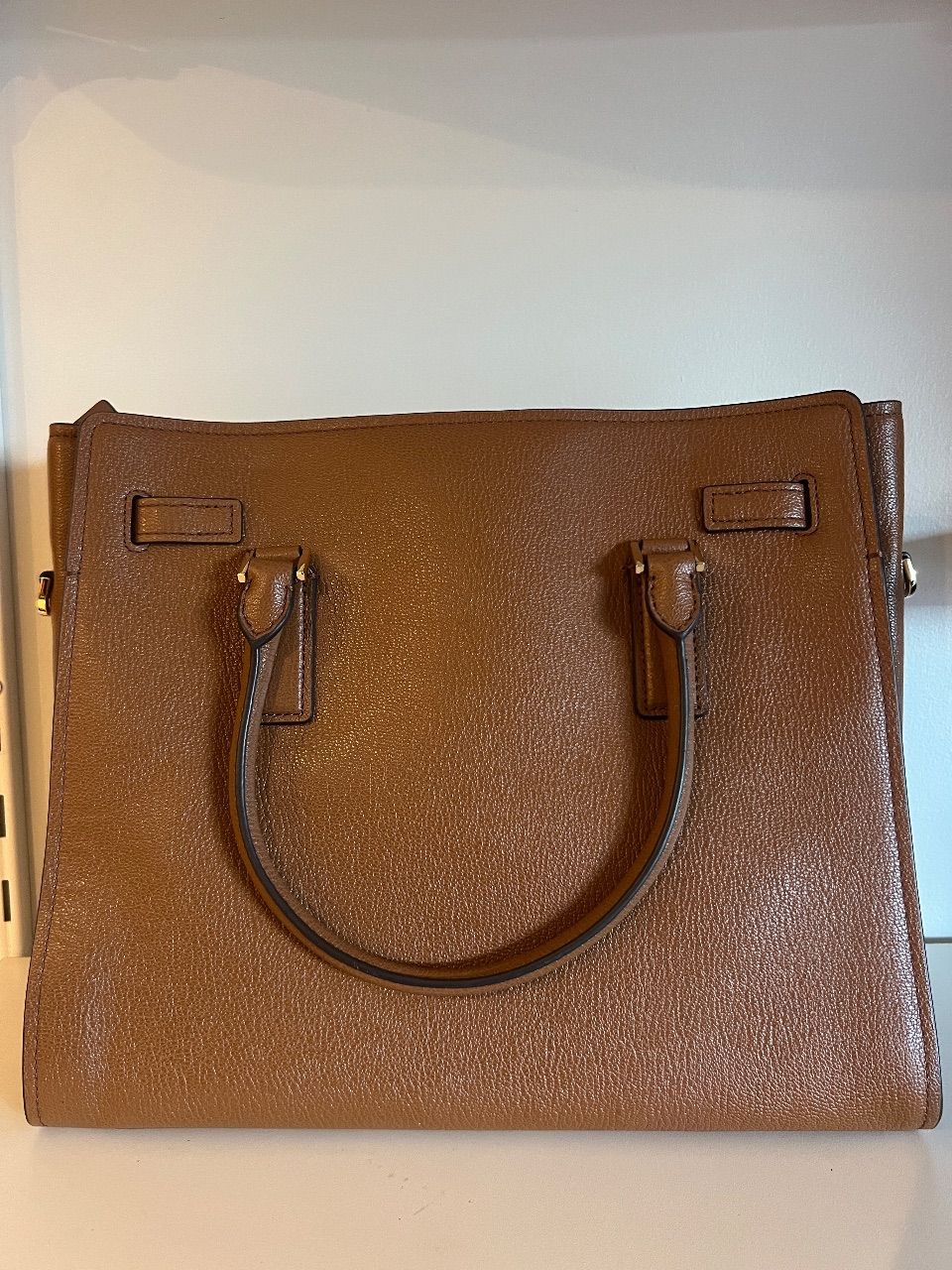 Bolsa tote de couro marrom com duas alças, cinto frontal e cadeado dourado — foto 6